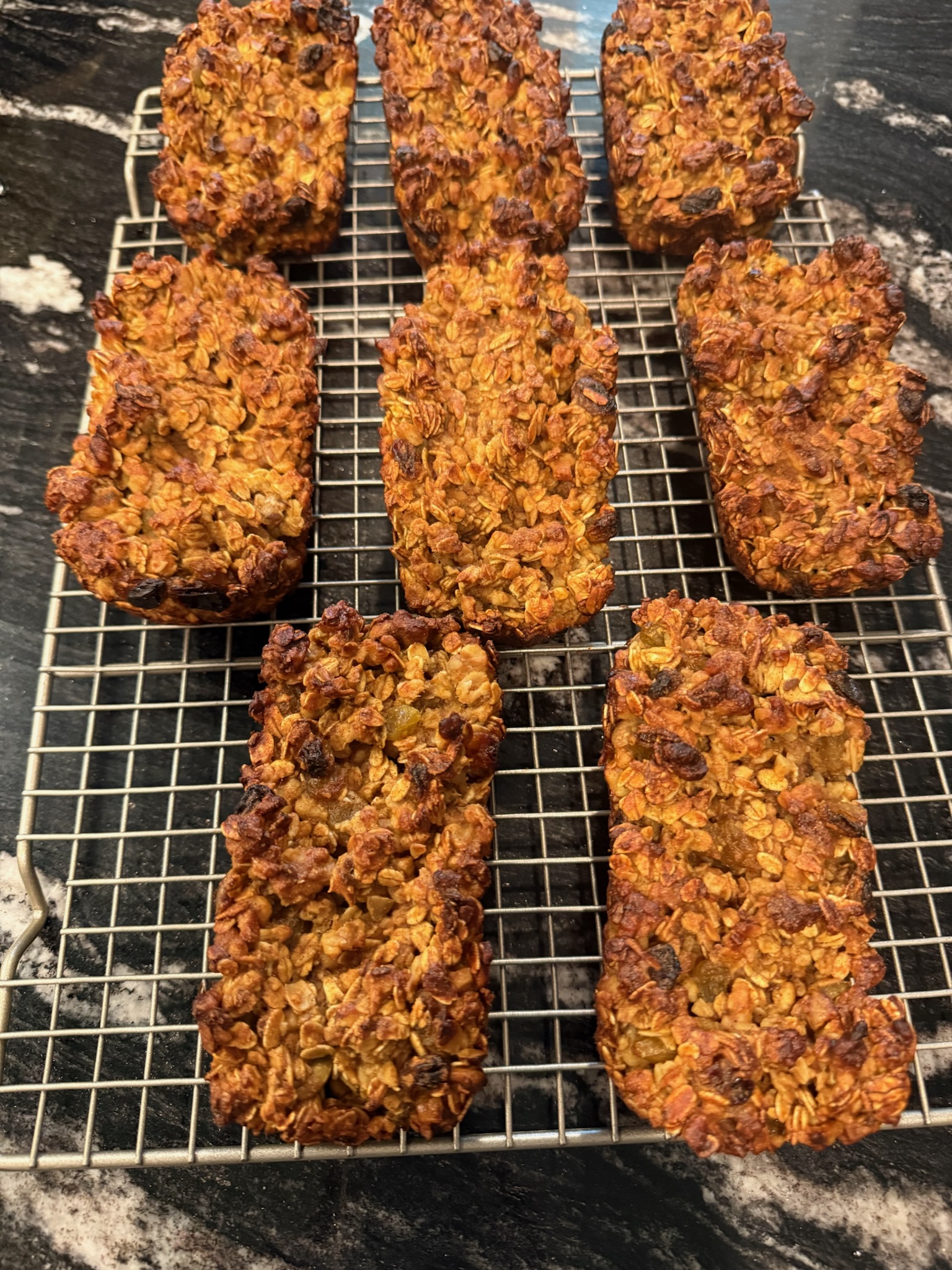 Mini pumpkin oatmeal banana bread loaves cooling on a rack.